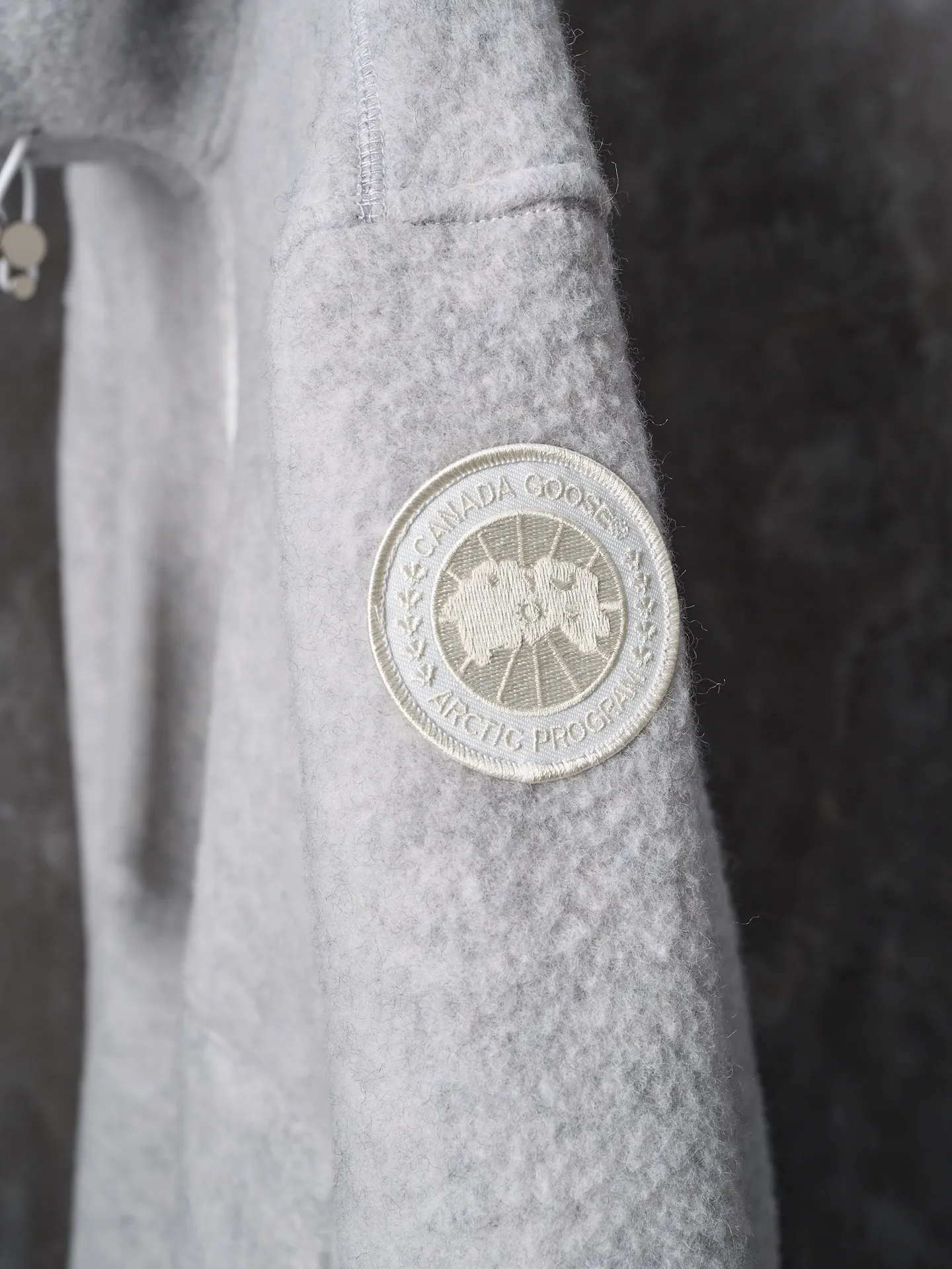 P780 Actual hanging auction] CANADA GOOSE/Canada Goose Chilliwack white label wool fleece hooded jacket [Ready stock] S M L XL Fabric selection: Wool fleece fabric made of wool as the main body and a very small amount of spandex and polyester fiber blended. Wool is a core natural ingredient that provides unparalleled temperature regulation, antibacterial and anti-odor properties and a skin-friendly feel. The feeding of a small amount of spandex gives the fabric a certain degree of four-way elasticity, making it non-restrictive during daily activities. As the basis of fleece's structure, polyester fiber enhances the fabric's durability, wrinkle resistance and quick-drying properties. It contributes to the loft of the fleece and provides functions such as trapping air.  Detail 1: The sleeves and hem are closed with 2×2 ribbing. Its strong elasticity can closely fit wrists and waists of different thicknesses, forming an effective 'seal' to prevent cold wind from blowing back. It can still maintain its original shape after repeated stretching and use, and is not easy to loose and deform. And the ribbed cuffs can convey a sense of design and enhance the visual beauty.  Detail 2: The combination of hood design and elastic buckle improves warmth and windproof performance when wearing.
